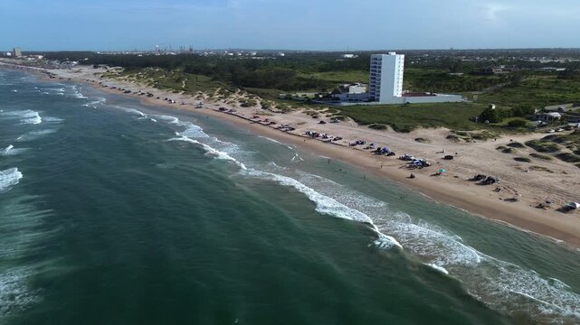Miramar Beach coastline with calm Gulf waters, sandy shore, local visitors, parked vehicles and natural green landscape