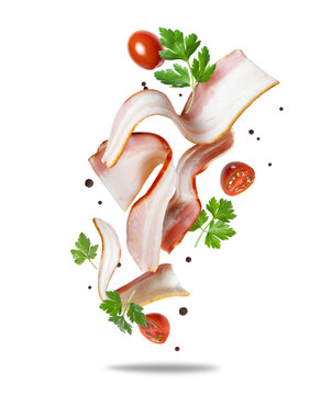 Sliced ​​bacon rashers with tomatoes and parsley in the air close-up on a white background
