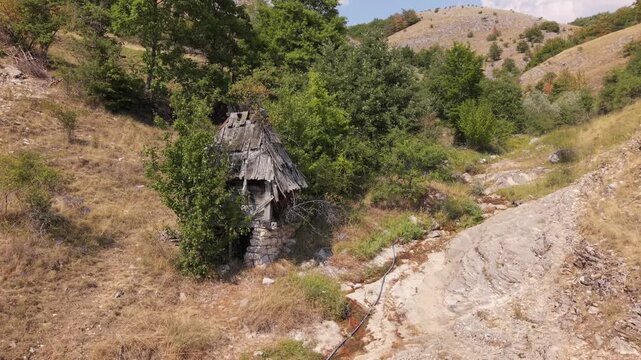 Aerial View of Drone Approaching Old Abandoned Wooden Watermill Beside Dried Riverbed in Bjelimici, Bosnia and Herzegovina
