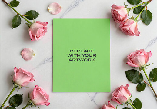 Vertical stationery mockup with green paper and placeholder text surrounded by pink roses on a white marble surface, Template, flat lay composition for branding print design presentation
