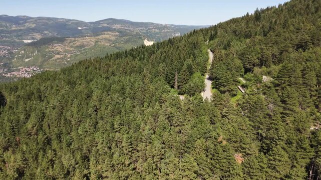 Aerial View of Drone Flying Over Trebevic Bobsleigh Track Revealing Quarry in Distant Mountains, Bosnia and Herzegovina