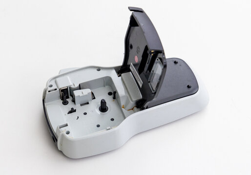 Open handheld label maker showing internal mechanism on white background
