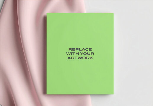 Vertical poster mockup displayed on a soft pink fabric background with white surface, realistic print presentation for graphic design, branding, advertising, editorial