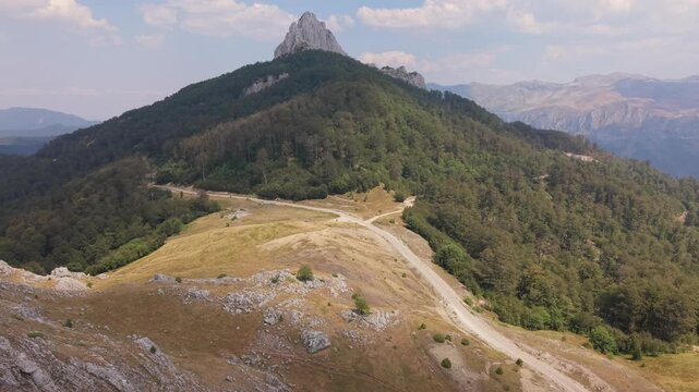 Aerial Drone Shot Flying Towards Forested Mountain Peak Under Blue Sky with Clouds, Visocica, Bosnia and Herzegovina