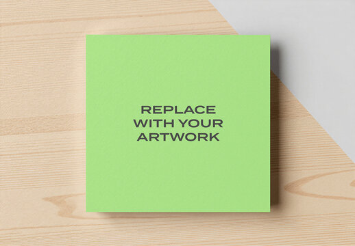 Square paper mockup with replace your artwork text on a wooden surface, minimalist stationery presentation, interior design display, graphic template