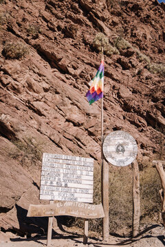 Wiphala flag waving near informative signs at el anfiteatro. A significant cultural heritage site in quebrada de las conchas. Salta. Argentina