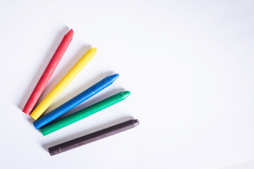 Fototapeta premium Box of soft pastel crayons and colored pencils on creative wooden table, close up