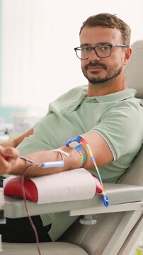 Male blood donor giving blood in a hospital donation center