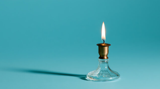 Single lit candle in a classic glass and brass candlestick holder against a vibrant teal background, soft light