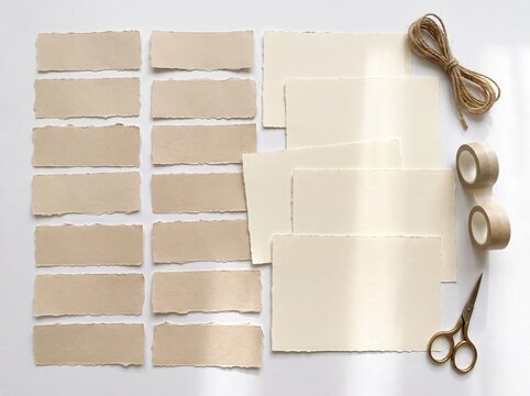 Handmade kraft paper tags and scissors on white background for crafting and labeling