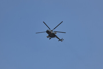 Fototapeta premium Military helicopter flying across blue sky