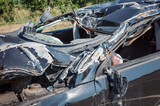 Crushed car roof, broken windshield and severe accident damage with collision wreckage and deformation.