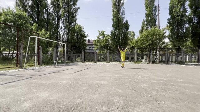 Teen boy training football shooting accuracy aiming at goal on outdoor court youth sport practice precision and technique concept. High quality FullHD footage