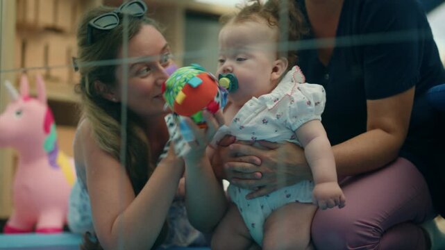 Mother holding and offering a pacifier to her upset baby, providing comfort and care in a loving family moment