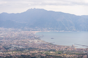Fototapeta premium Panoramic coastal city beneath a mountain range