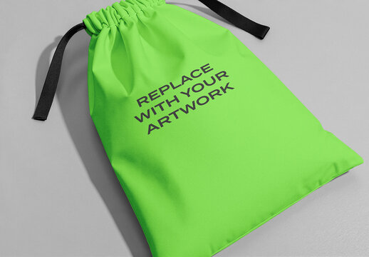 Drawstring bag mockup with text placeholder on a gray surface, realistic product presentation for branding and graphic design, template artwork display