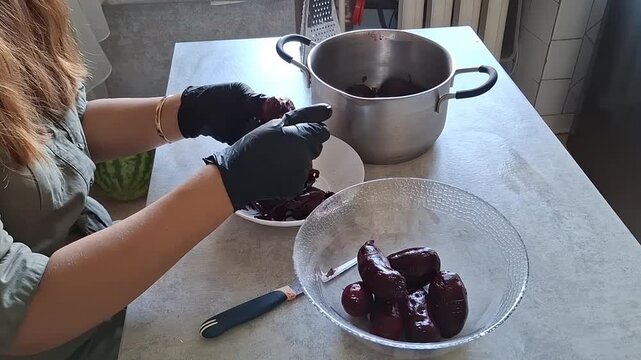 Preparing beets in a kitchen with gloves and tools on a table
