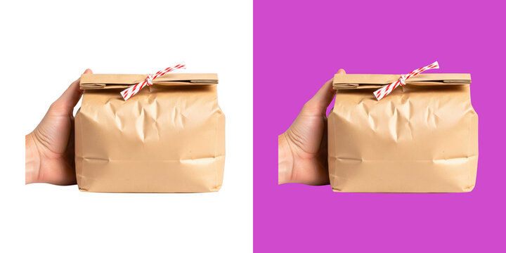 A person hand holding a brown paper bag with striped string tie transparent png