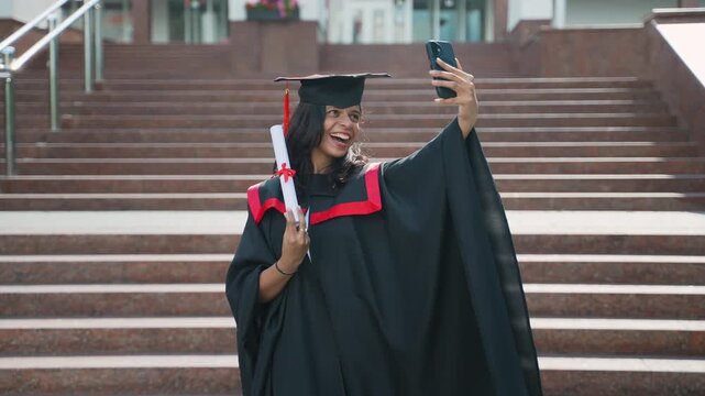 Happy female graduate taking selfie with diploma