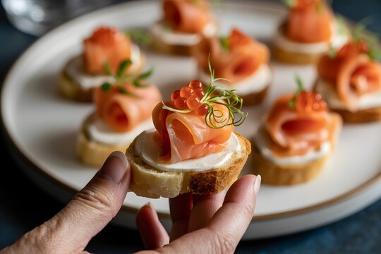 Woman holding salmon canape sandwich on plate with cream cheese and caviar