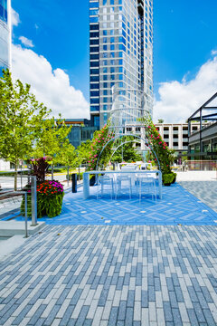 Colorful flowering structure creates a distinctive centerpiece within a paved public courtyard.