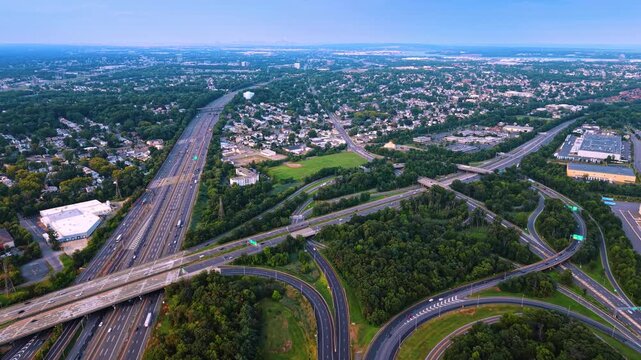 Complex road system passing through the area with beautiful lush greenery. Drone footage over New Jersey Turnpike interchange at sunset.
