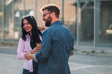 Fototapeta premium Diverse friends talking and smiling in urban setting, enjoying city lifestyle and real connection