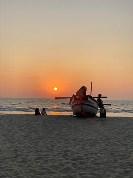 Traditional fishing boat on Arambol Beach at sunset in Goa, India