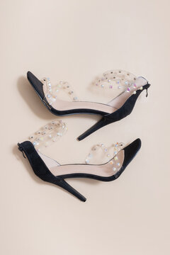 High heel shoes with pearl details on a light background
