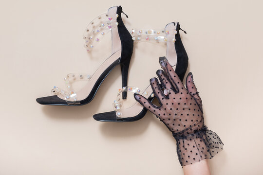 High-heeled shoes are paired with gloves on a flat surface during a fashion display