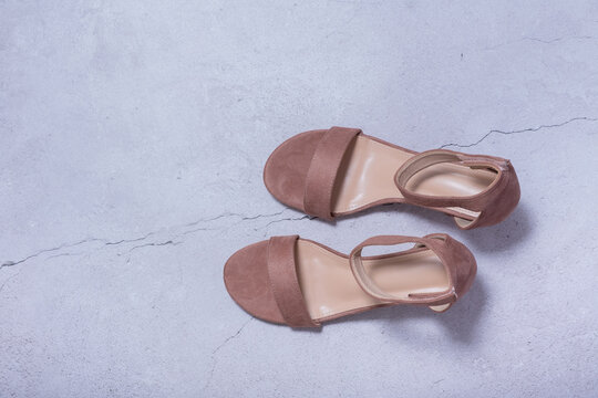 Brown sandals placed on a light gray surface