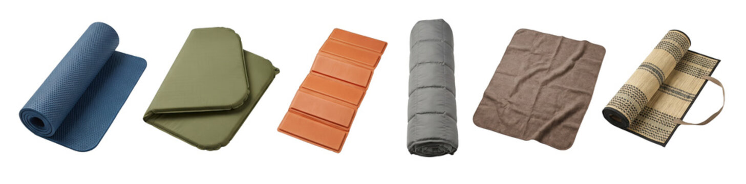 Various types of tourist and camping mats and pads, including a rolled yoga mat, inflatable mattress, foam pad, sleeping bag, and blanket, are displayed in a neat row