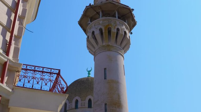 Grand mosque of constanta minaret and dome against blue sky. Detailed upward view of the historic minaret and dome of the grand mosque of constanta, also known as the carol I mosque