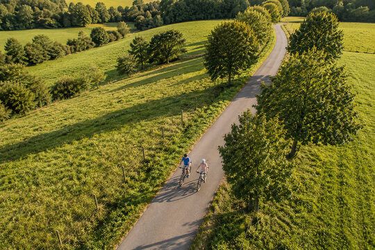 Aerial View of Active Senior Couple Cycling on Scenic Country Road