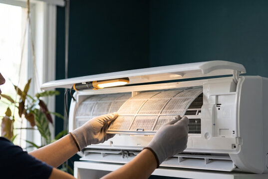 Close-up of technician hands repairing an indoor air conditioner