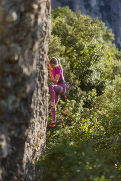 Young woman rock climbing a challenging route outdoors