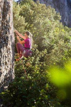 Young woman rock climbing outdoors enjoying nature