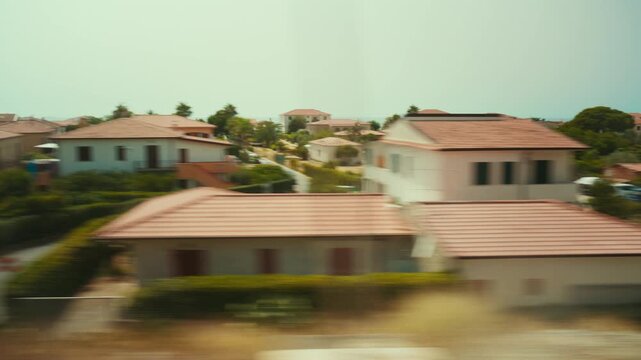 Train journey with a view of holiday homes near the sea in Italy