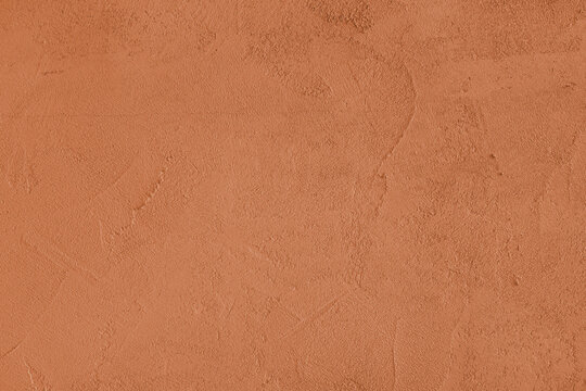 Orange stucco wall, uneven plaster surface, painted distressed concrete texture background. Abstract grunge backdrop, wallpaper for design, construction design element