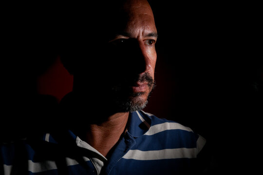dark-haired, white European man with a trimmed beard, of mysterious appearance and light.