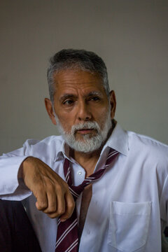 Pensive Mature Man Leaning Forward in Loose Shirt and Tie