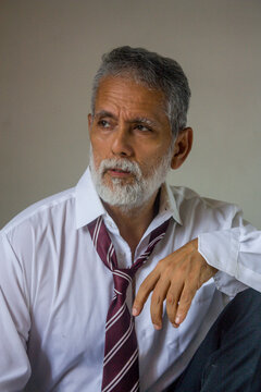 Senior Handsome Man Looking Away with Hand on Leg Portrait
