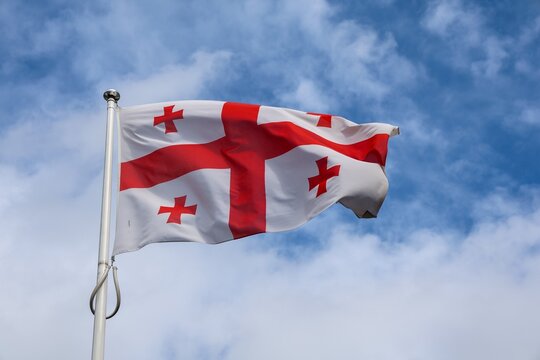Georgian flag with its red crosses waving in the wind under a cloudy sky