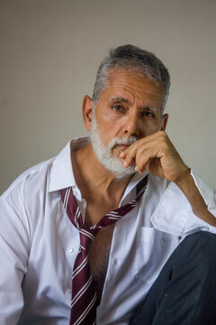 Thoughtful Senior Man Resting Chin on Hand Studio Portrait