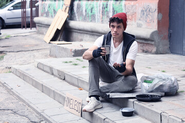 Obraz premium Homelessness and poverty, young man begging for money on city street, social issues and economic hardship