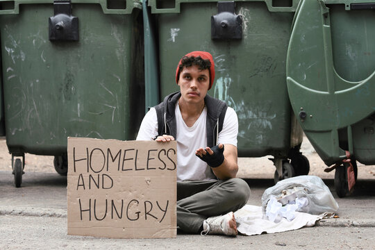 Homelessness and poverty crisis, young man begging with a homeless and hungry sign on the street