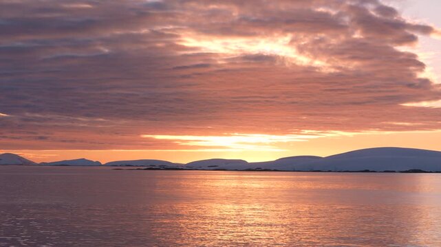 Stunning Sunset in Antarctica. Cruise Ship View Sailing Through Ocean Purple, Orange, Colorful Sky and Clouds. Beautiful Nature.