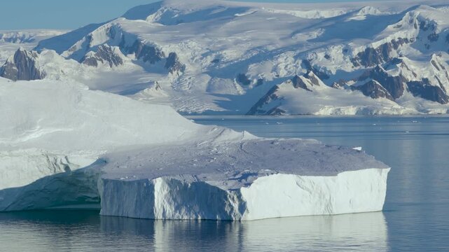 Antarctica Sailing Past Huge Tabular Iceberg Close Up with Beautiful Landscape of Mountains Covered in Snow, Ice, Glaciers Behind. Remote Nature