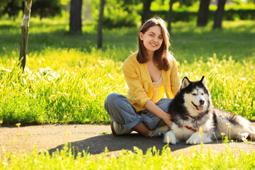 Pet ownership and companionship, young woman with husky dog in a sunny park, outdoor leisure and animal bond © Pixel-Shot