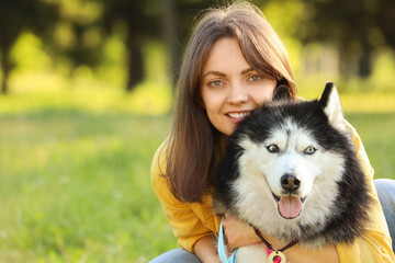 Pet ownership and animal companionship, happy young woman with her siberian husky dog in a sunny park © Pixel-Shot